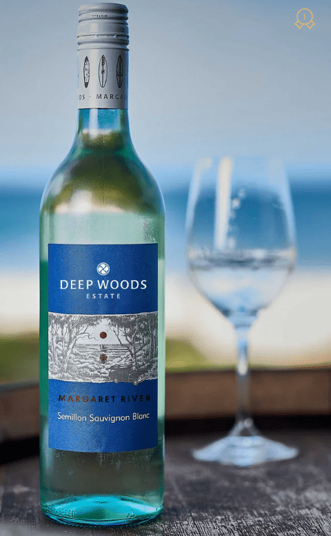 a person drinking deep woods ssb at the beach. Bottle on a wine barrel.